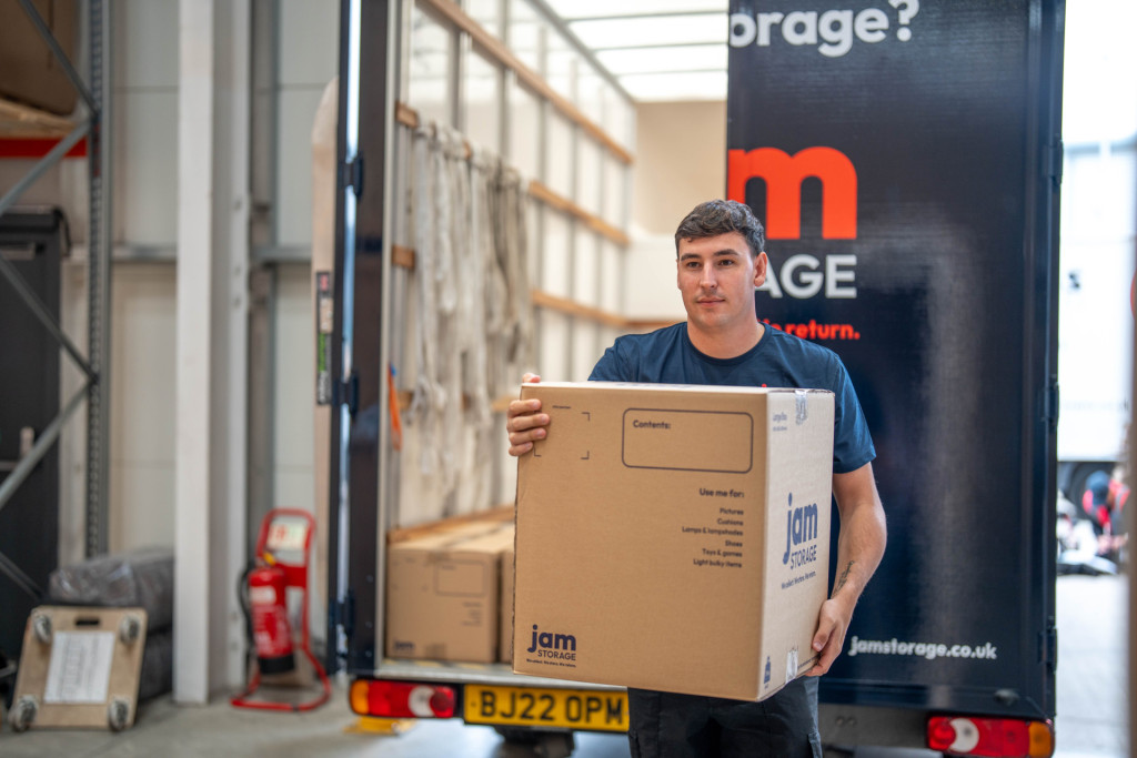 Jam Storage team member carrying boxes off the back of a van