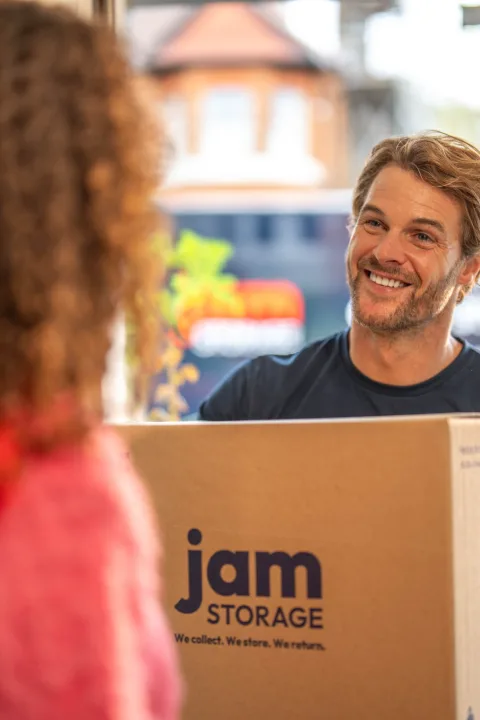 JamStorage team member handing a JamStorage box to a customer at her front door